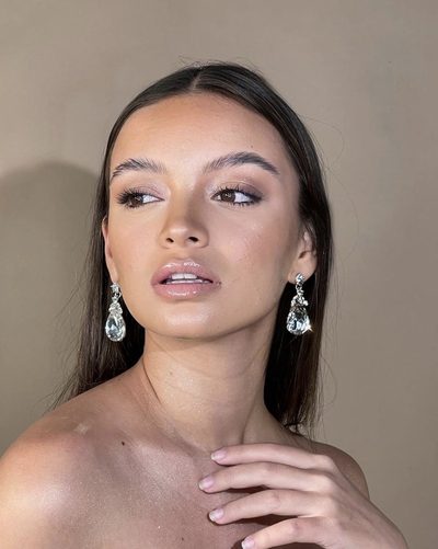 Beauty campaign close-up showing makeup and statement crystal earrings